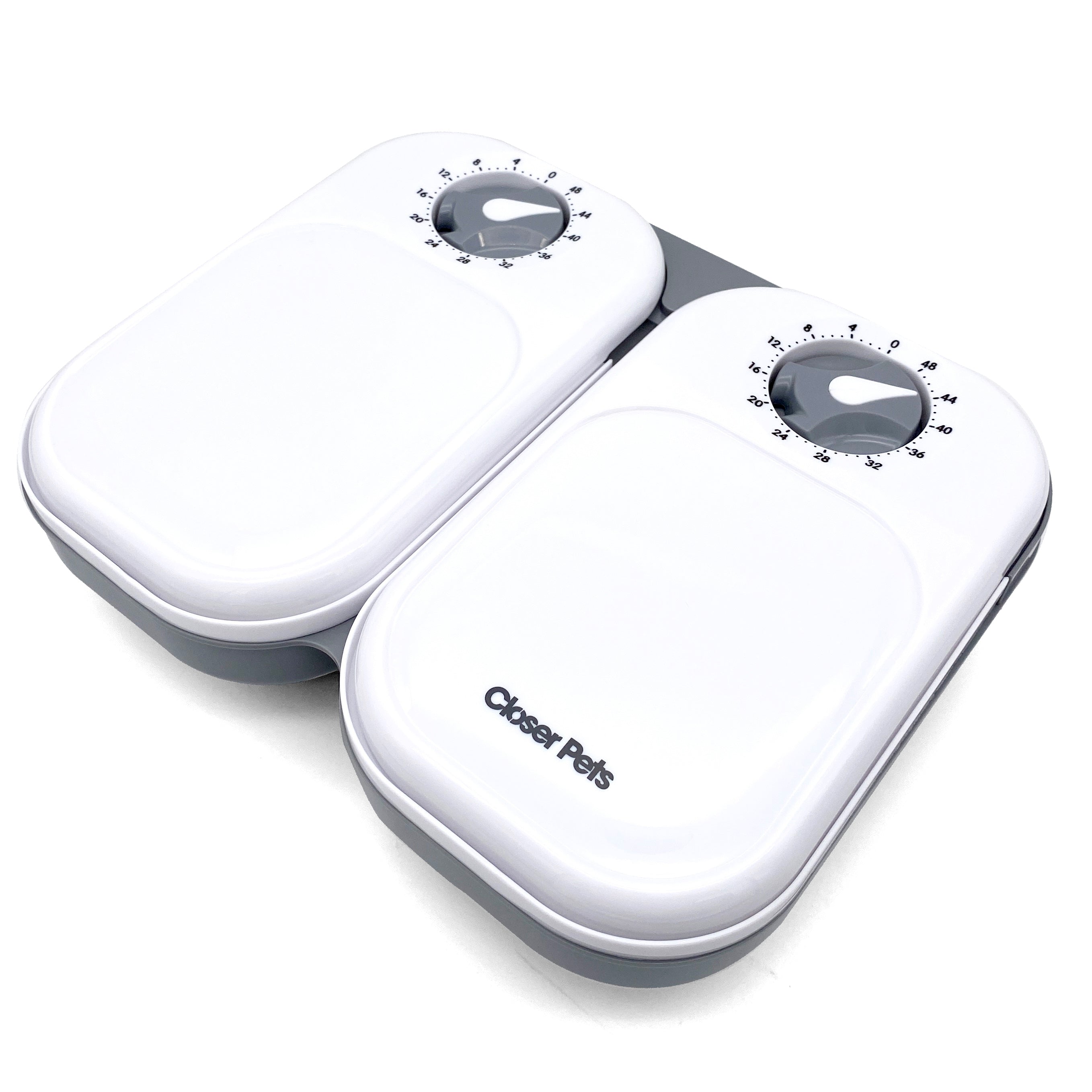 Top view of a closed grey and white two meal pet feeder on a white background