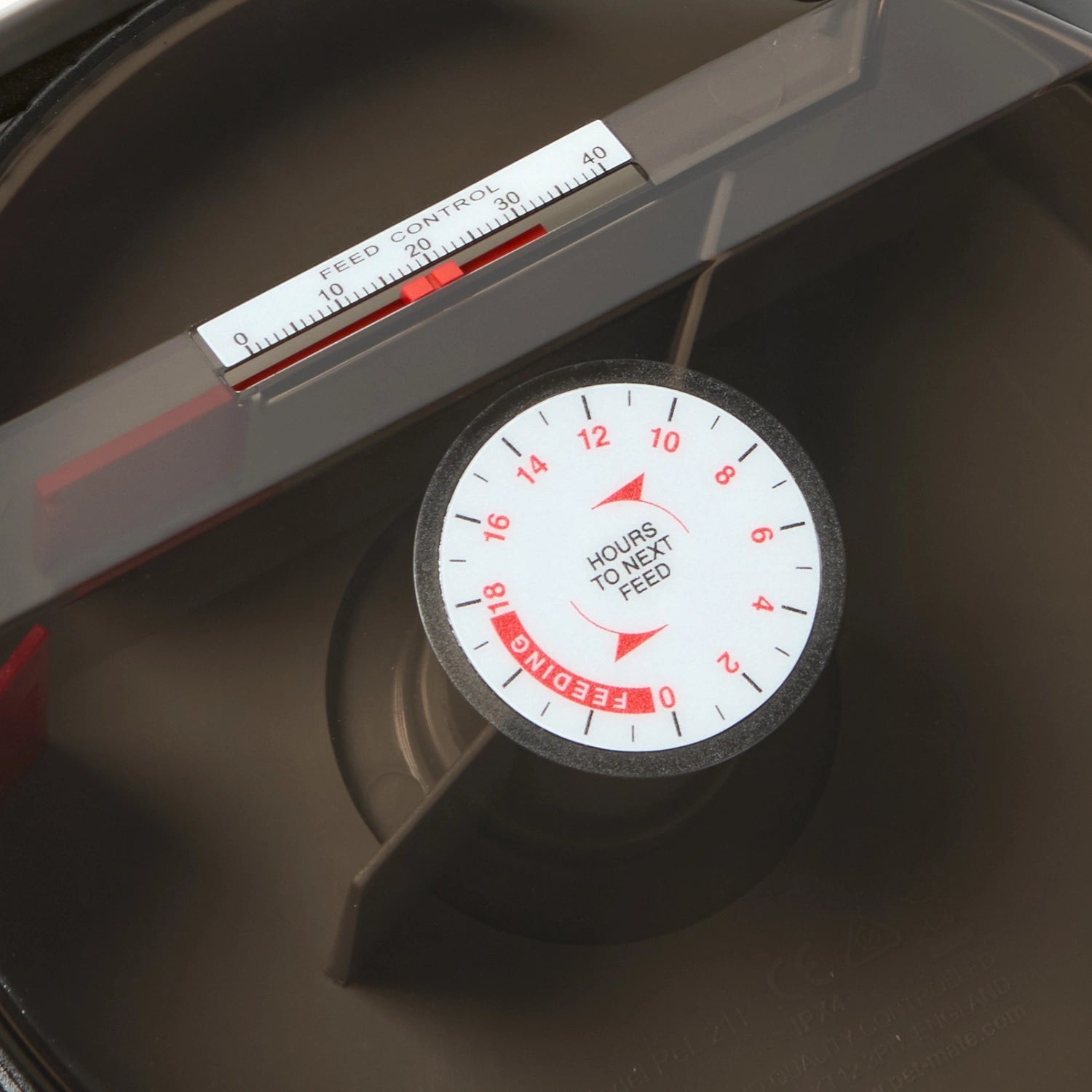 Automatic feeder for pond fish with digital display and control panel on a dark background