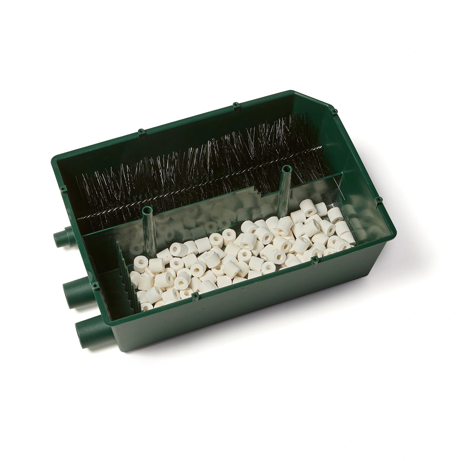 An overhead view of the inside of the green gravity pond filter with white pellets and a black bristle brush on a white background