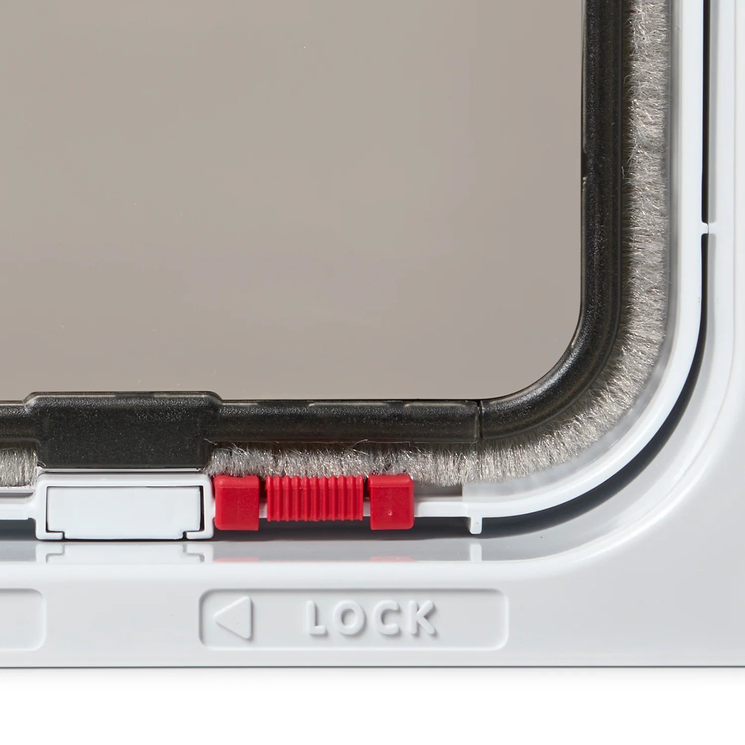 Close up view of the red lock and label on the white cat flap