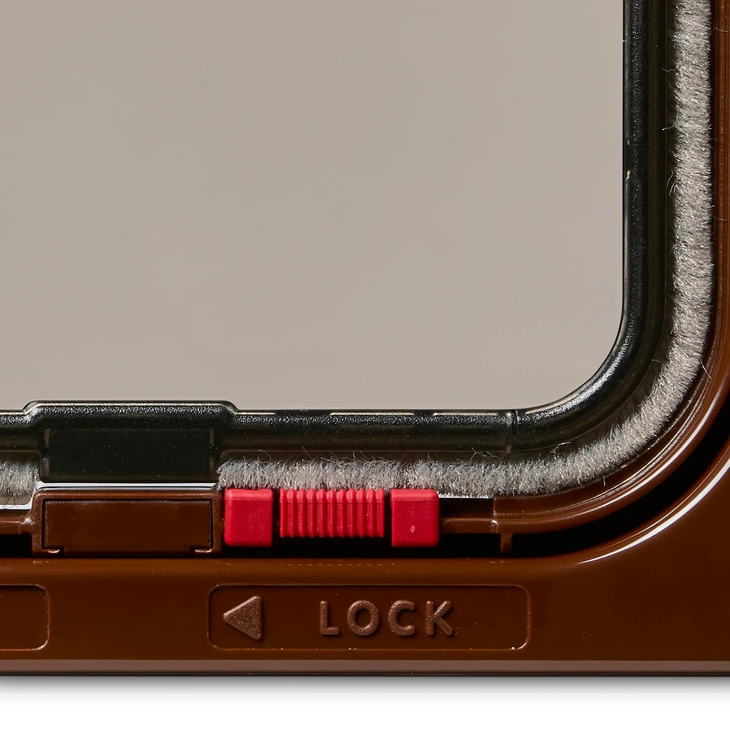 A close up view of a lock on this two way locking cat door in brown