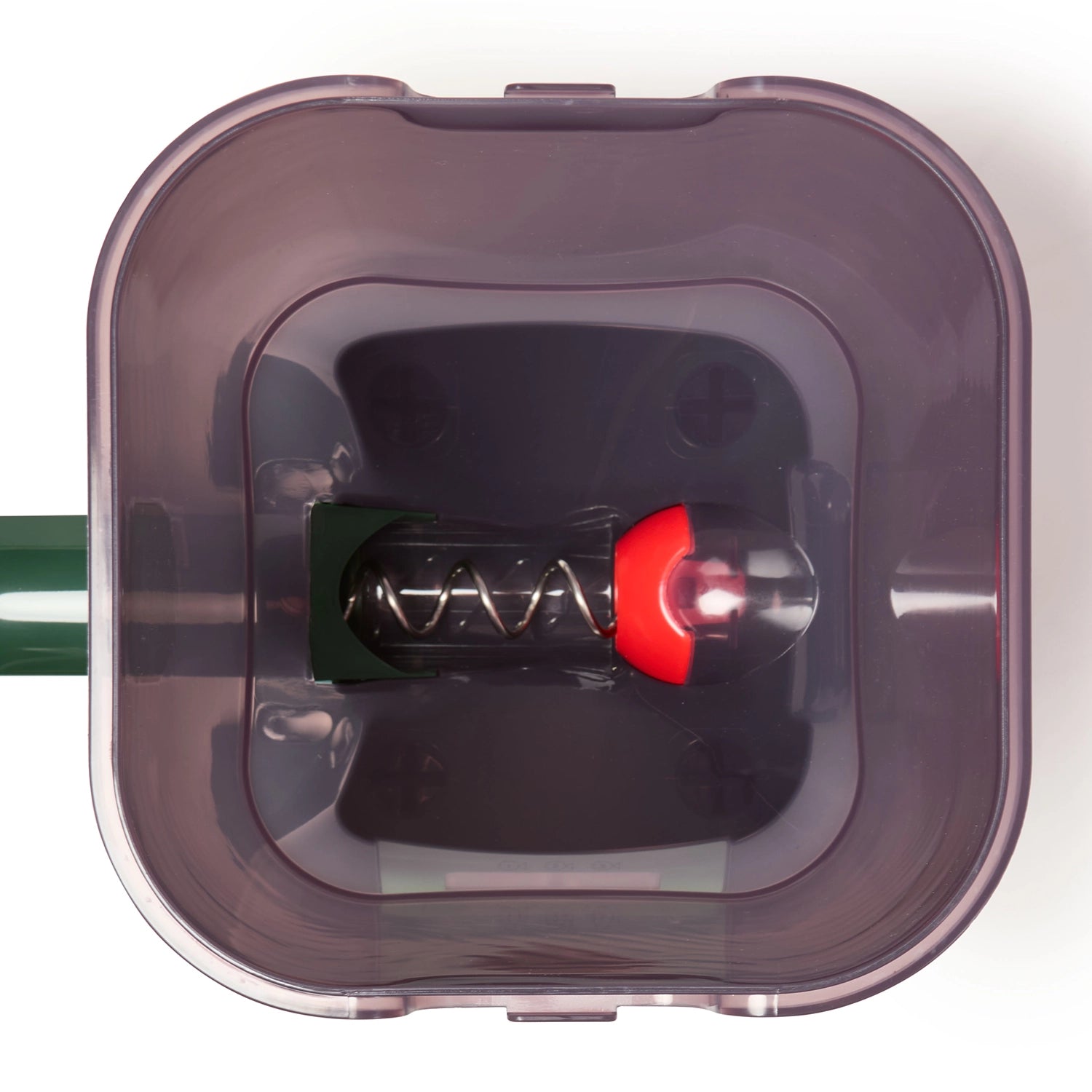 Close-up of the empty transparent plastic container with a red and green component inside on a white background