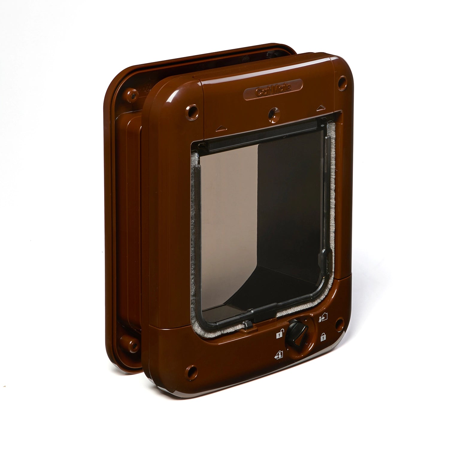 Side front angle view of a brown pet door, displaying the clear plastic flap and the manual locking dial on a white background