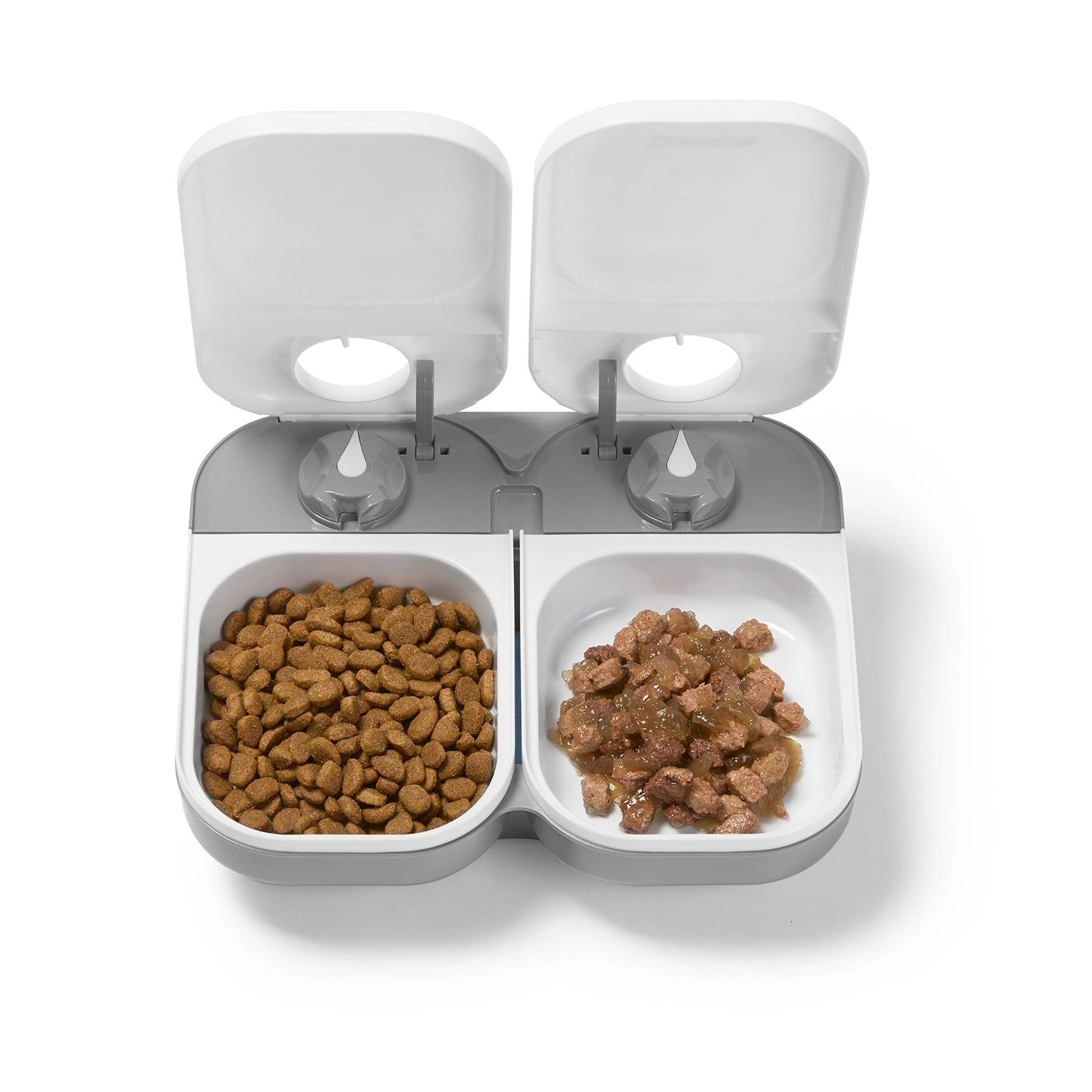 Pet feeder with white lids and bowls on a grey base for cats and small dogs with two compartments filled with kibble on a white background