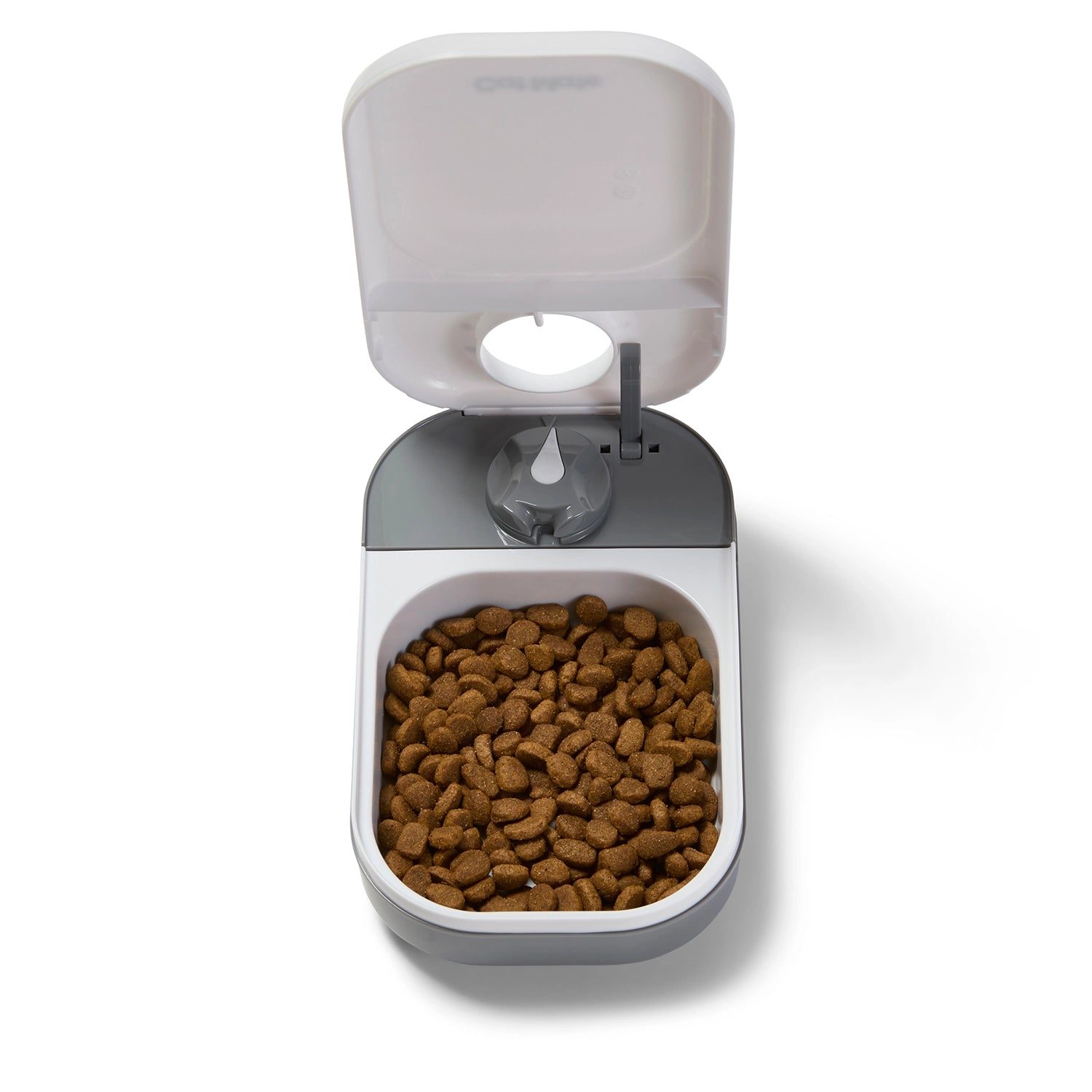 A top view of the open-lid one meal pet feeder displaying a portion of dry pet food in the white bowl which fits in to a grey feeder base, on a white background