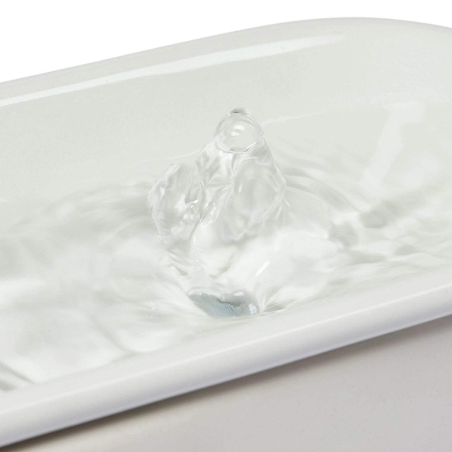 A closeup image of flowing and bubbling water across the light grey ceramic drinking area of the Cat Mate ceramic fountain which is suitable for cats and small dogs to drink from, on a white background.