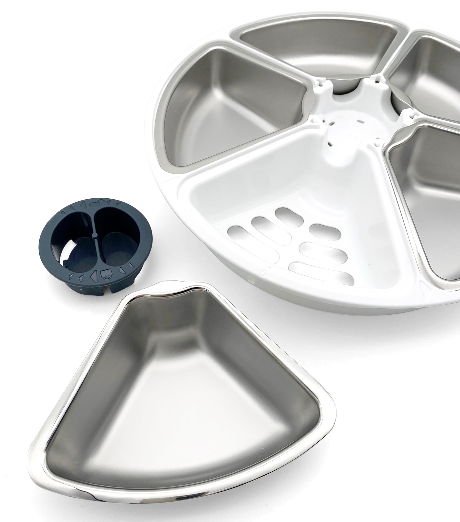 A visible carousel with four stainless steel bowl inserts, with a fifth stainless steel insert in the foreground on a white background