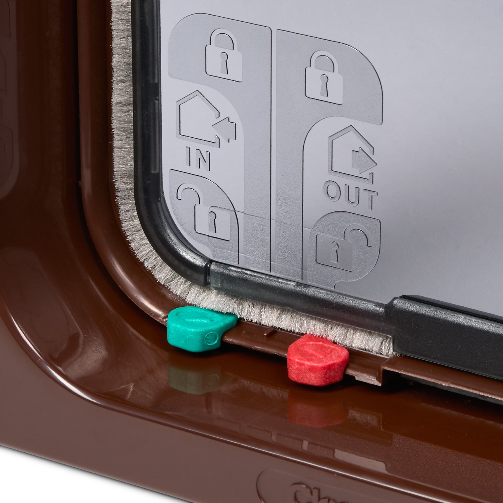 Pet door with a manual lock mechanism and two coloured plastic keys on a white background
