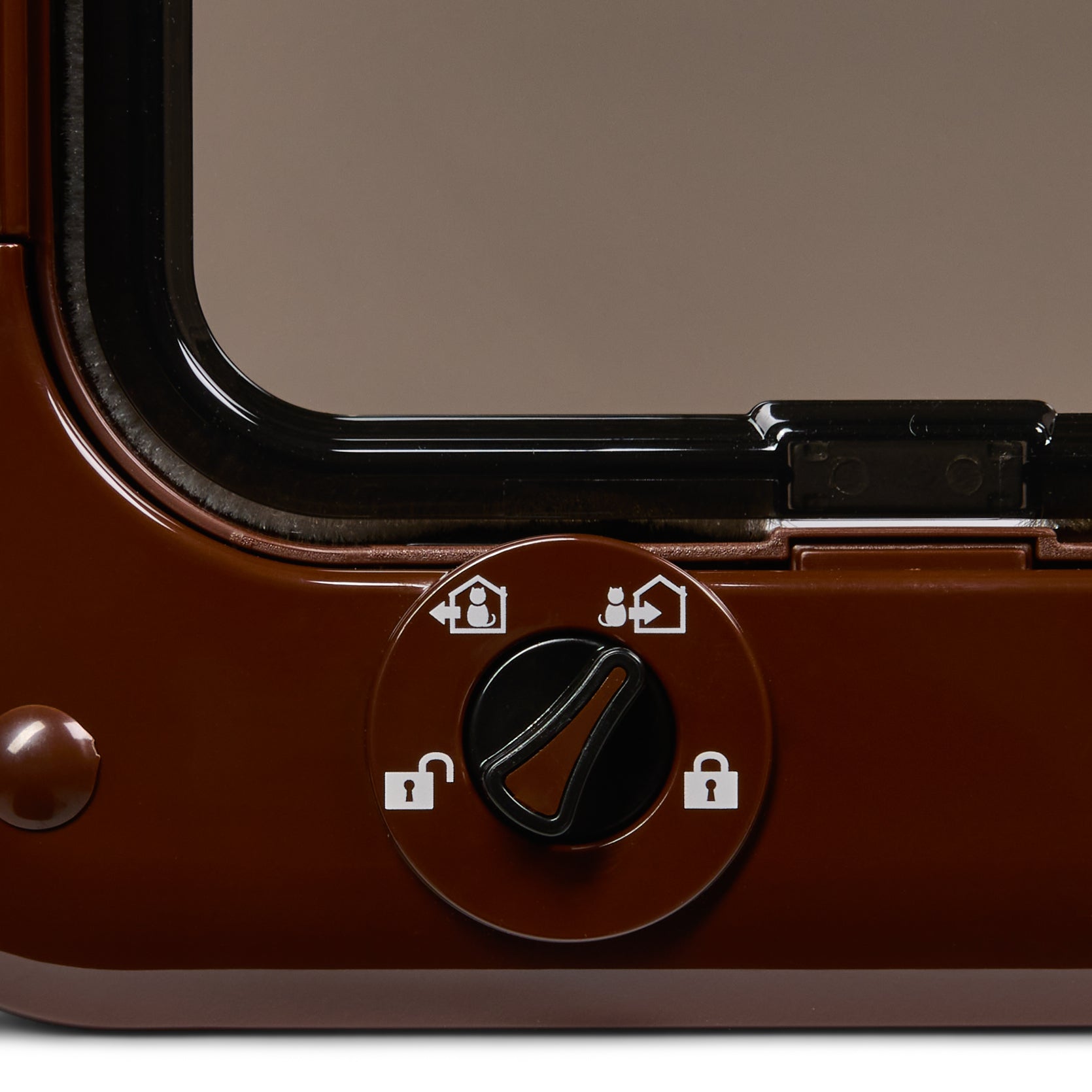 Close-up of the brown manual lock mechanism with white symbols which portray the different lock options of 'in only', 'locked', 'unlocked' and 'out only' 